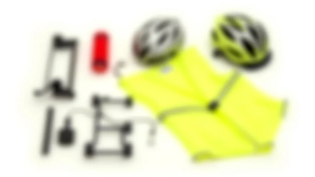 Collection of bicycle safety equipment: bright LED lights, reflective gear, safety helmet, and high-visibility clothing arranged on table, professional product photography